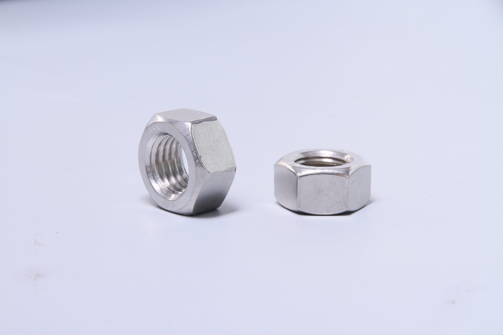 Two metallic hex nuts