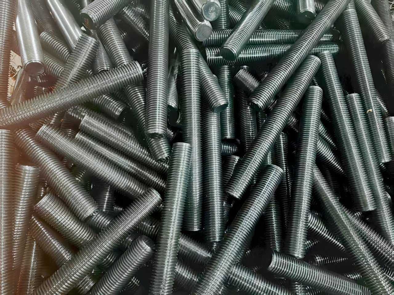 A pile of metal threaded rods
