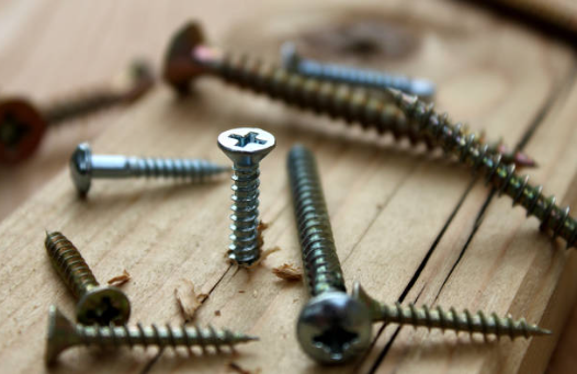 Various screws on wooden surface