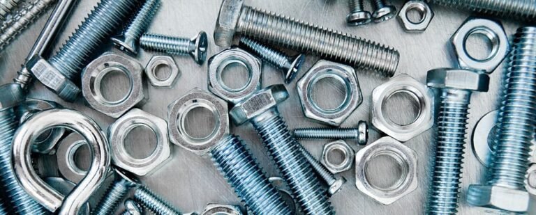 Nuts, washers and bolts on scratched metal background.